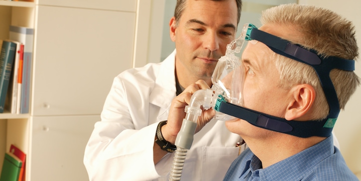 Doctor and sleep apnea patient with CPAP device