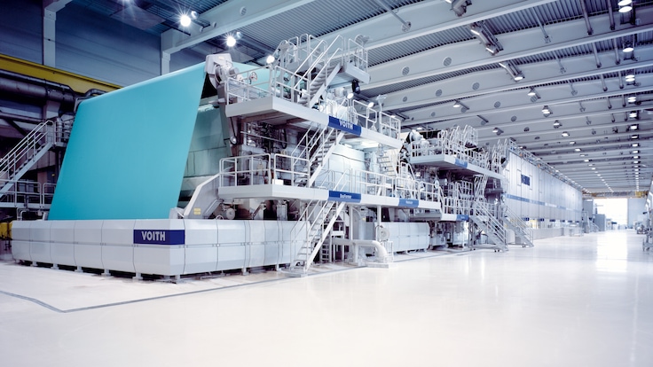A huge paper production machine inside an industrial hall.